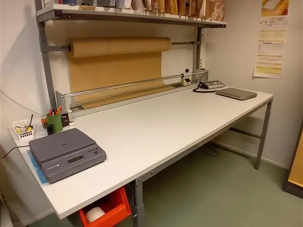 Pakkauspöytä, ylähyllyllä ja pakkauspaperitelineellä